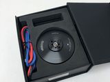 une boîte ouverte contenant un lecteur CD, posée sur une surface blanche