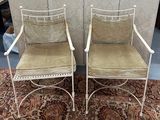 une paire de chaises en fer blanc avec des coussins verts, posées sur un tapis