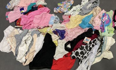 a pile of underwear on the floor next to a pair of scissors