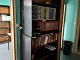 a black bookcase in the corner of a room with a blue wall