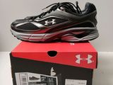 une paire de chaussures de course noires et rouges posée sur une boîte