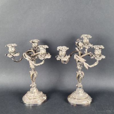 a pair of silver plated candlesticks with flowers and leaves