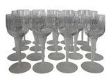 twelve clear wine glasses lined up in a row on top of each other
