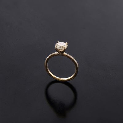 a close up of a gold engagement ring on a black surface