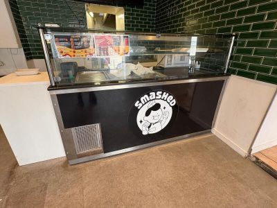 un comptoir avec une pizza posée dessus dans un restaurant