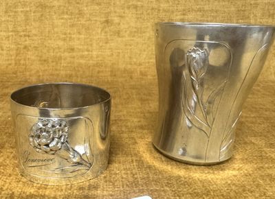une coupe en argent et une autre coupe en argent posées sur une table