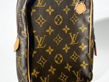 un gros plan d'un sac Louis Vuitton posé sur une surface blanche