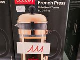 Trois boîtes de café pour cafetière à piston sont posées sur une étagère dans un magasin.