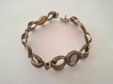 a close up of a bracelet on a white surface