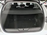 the back of a white car with its trunk open in a parking lot