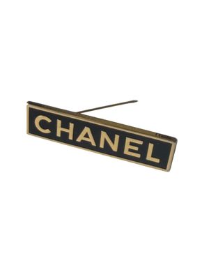Broche CHANEL, fantaisie en métal doré sur fond noir