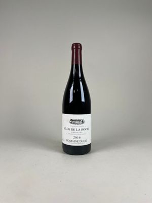 une bouteille de vin rouge posée sur une table blanche
