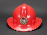 a red fireman ' s hat with a badge on it