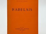 un livre orange avec des inscriptions noires posé sur une surface blanche