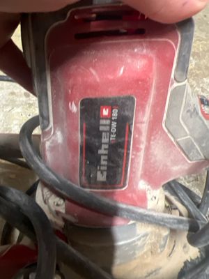 une personne tenant une ponceuse filaire à la main