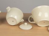four pieces of white porcelain tea set on a table