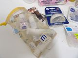 a mesh bag filled with baby items on a table