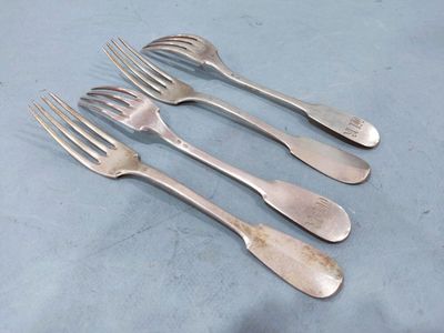 four forks and a spoon are sitting on a table