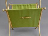 an old fashioned magazine rack with a green cover and gold trim