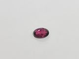 a pink tourmaline stone on a white surface