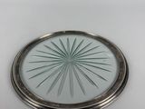 a close up of a silver plate with a circular design on it