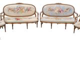 Plusieurs chaises et un canapé sont disposés en cercle sur un fond blanc.