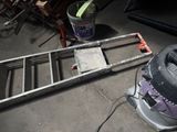 une photo représentant une échelle et un seau de peinture dans un garage