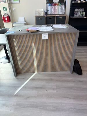 un chat assis par terre devant un bureau