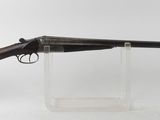 un fusil posé sur un socle transparent, devant un fond blanc