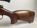 a close up of a rifle on a white background with a gun in the foreground