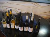 bottles of wine are lined up on a table in front of a painting