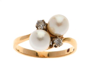 une bague en or ornée de deux perles et de diamants