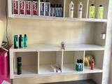 une pièce avec une étagère sur laquelle sont posés divers produits capillaires