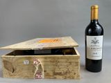 une bouteille de vin posée à côté d'une caisse en bois