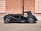 an old black car parked in front of a brick building