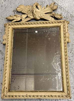 miroir à cadre doré accroché au mur, orné d'un motif représentant un oiseau et des feuilles