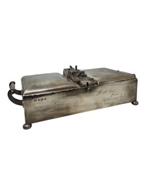 an old metal box with writing on it sitting on a white surface