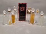 five bottles of perfume sitting next to each other on a white surface