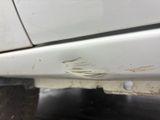 a white car that has a hole in the side of it