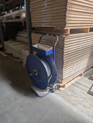 a machine that is sitting in front of a pile of wood