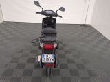 a motor scooter parked in a room with a checkered floor
