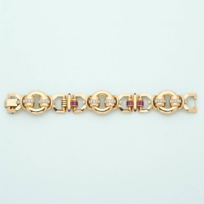 a close up of a gold bracelet with pink stones