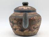 an image of a brown vase with a dragon design on the lid