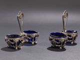 three silver and blue glass bowls and spoons on a gray surface