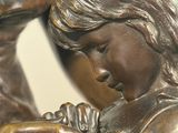 a bronze statue of a girl holding a bird