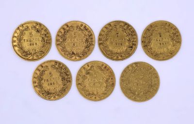un groupe de cinq pièces d'or posées sur une surface blanche