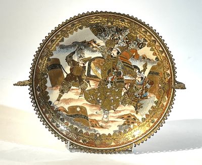 une assiette en or sur laquelle est représenté un cheval et son cavalier