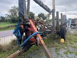 a man that is standing on a forklift in the grass