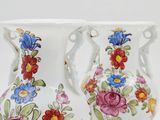 two vases that are decorated with flowers on them