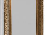 un miroir à cadre doré accroché à un mur blanc, à côté d'un mur